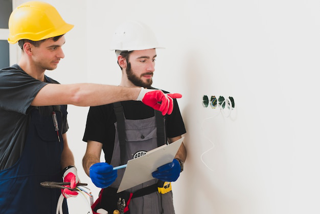 Electrical contractors examining a home’s electrical wiring