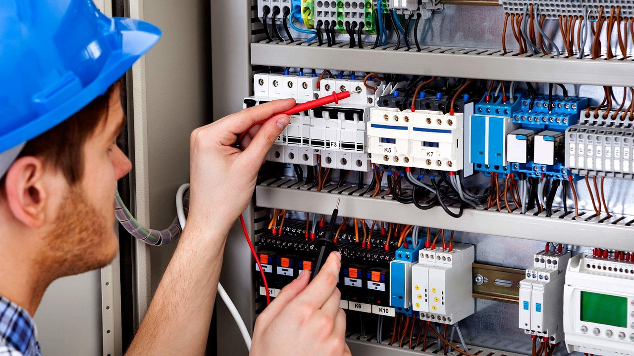 Electrician testing a residential electrical panel with multimeter tools