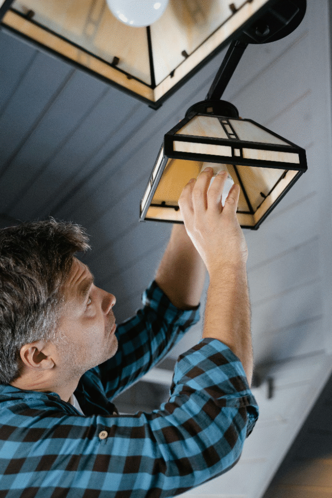 Man inspecting ceiling light fixture for signs of electrical problems