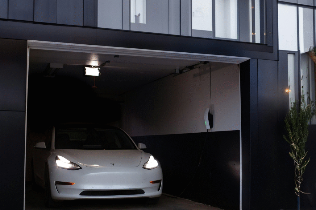 Tesla charging inside a modern garage with an EV wall charger